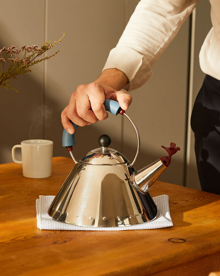 Der ikonische und unverkennbare 9093 bird whistle kettle von Michael Graves. Kegelförmiger Wasserkocher aus Edelstahl für Induktionskochfelder mit mehrfarbigen Griffen.